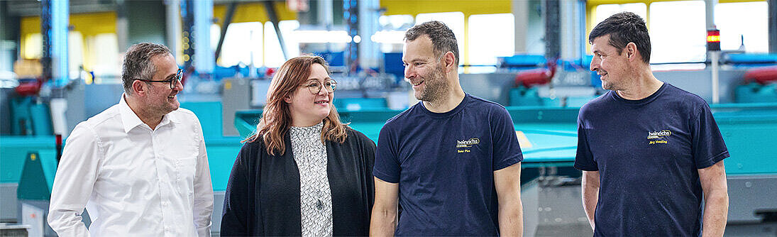 Gemischtes Team in der Werkhalle von heinrichs