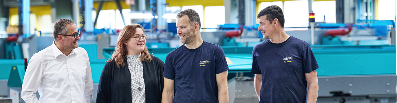 Gemischtes Team in der Werkhalle von heinrichs