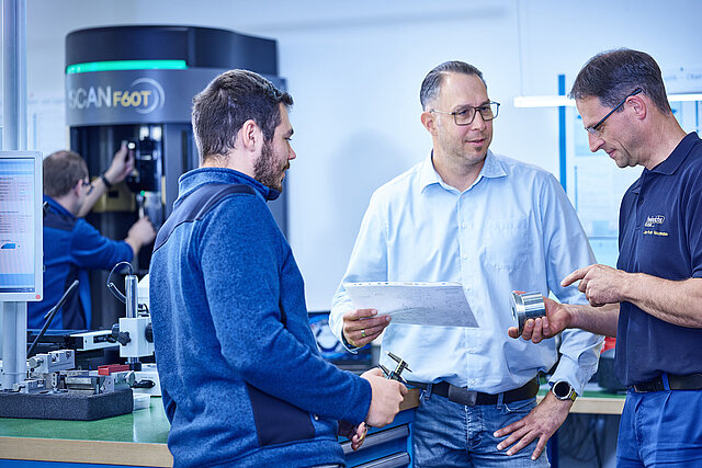 Drei Mitarbeiter bei der Abstimmung in der Qualitätssicherung