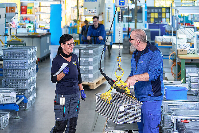 Mitarbeiter im Gespräch in der Produktionshalle von heinrichs drehteile