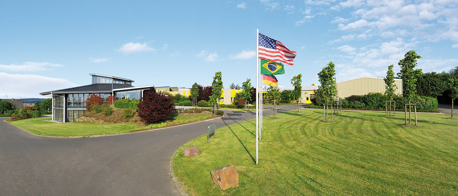 Außenansicht des Unternehmens heinrich drehteile mit den drei Länderflaggen