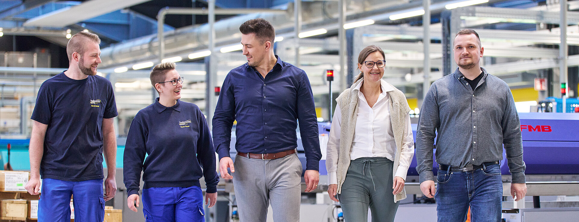 Gemischtes Team in der Werkhalle von heinrichs